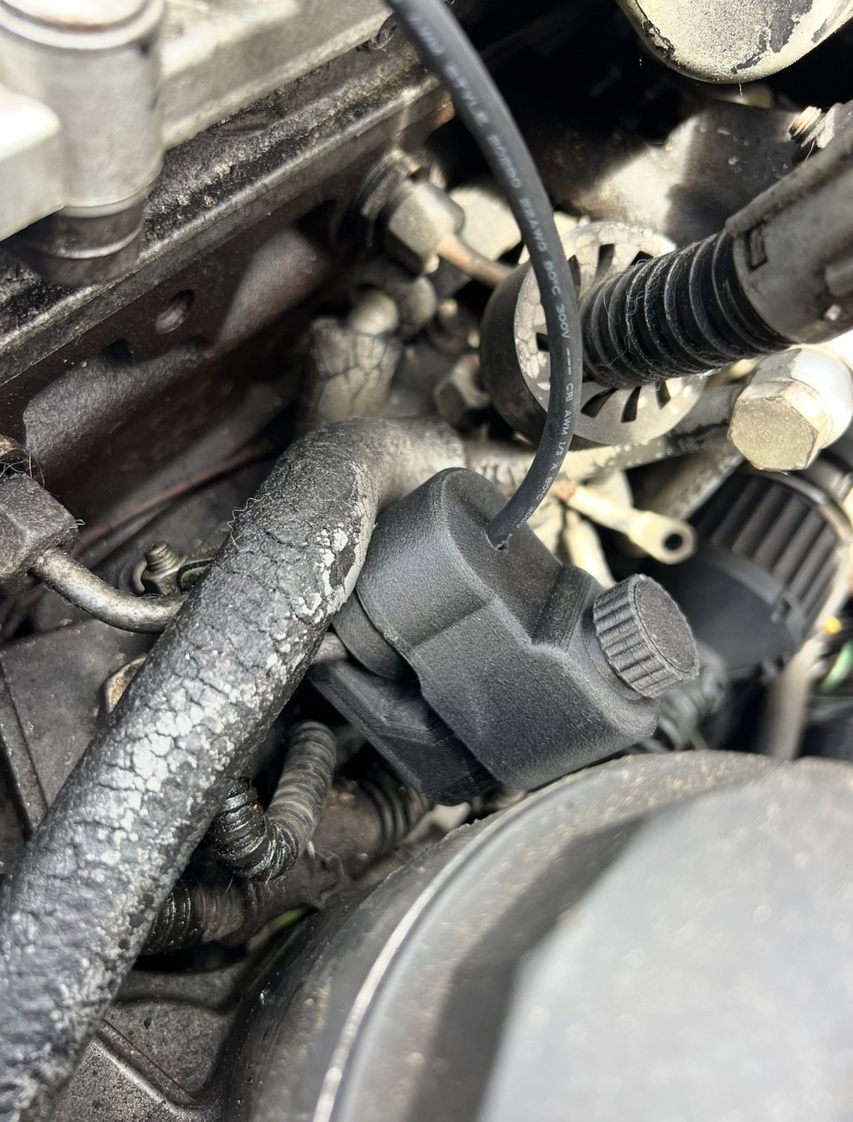 The line-clamp probe installed on an injection line in the engine bay