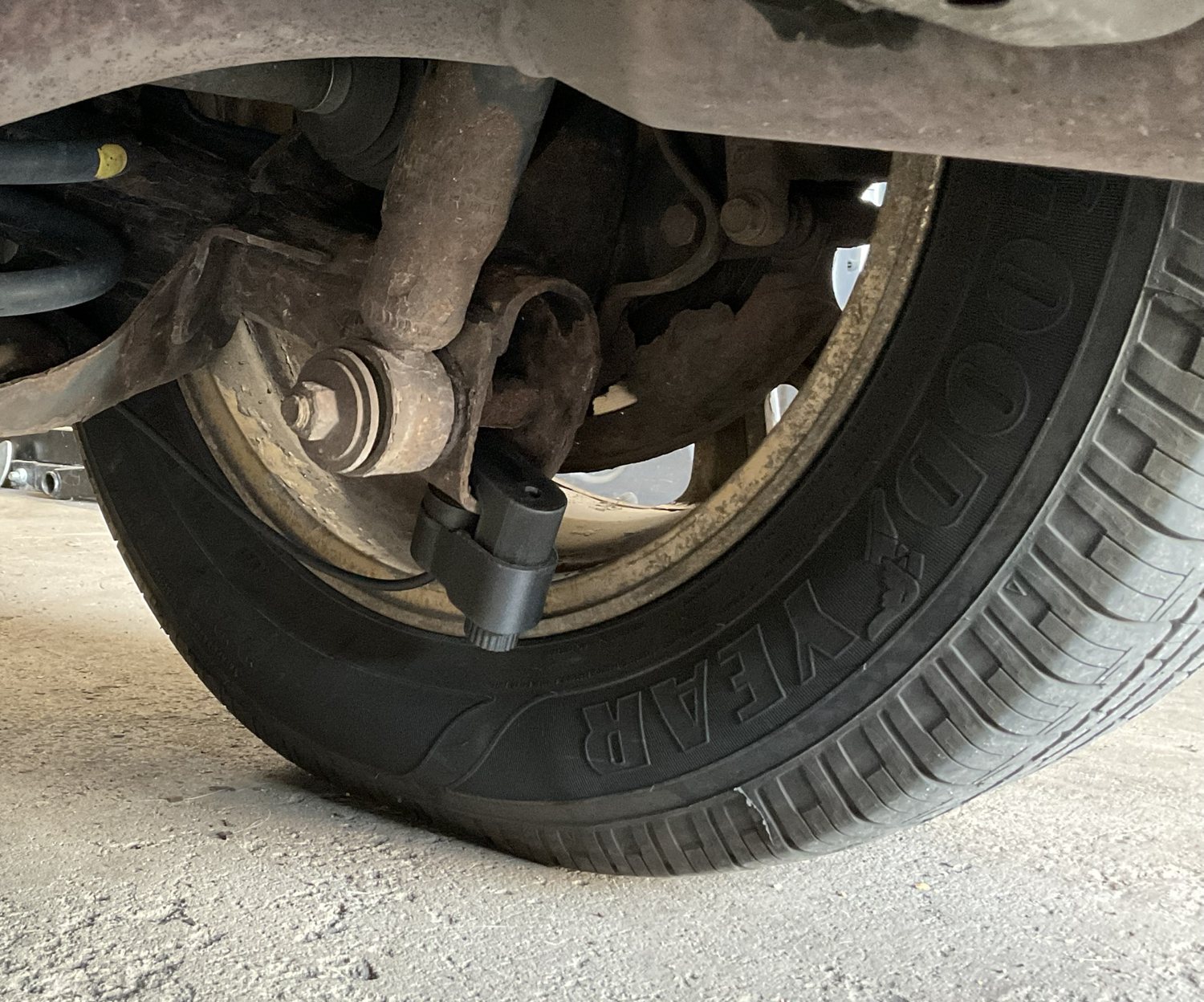 The Timing Buddy vibration probe clamped to the suspension next to a wheel on the 2006 Sienna